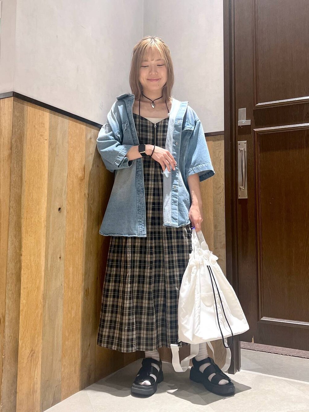 ブラック系のショルダーバッグ、ブラック系のワンピース、ホワイト系のキャミソールを着用したレディースの夏コーディネートの5枚目の写真