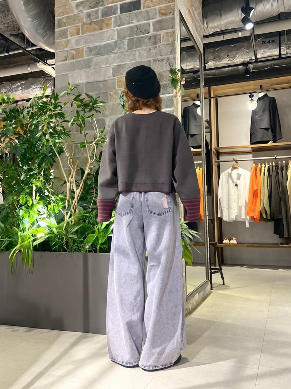 ブラック系のスリッポン、グレー系のカーディガン/ボレロ、ピンク系のデニムパンツを着用したレディースの秋コーディネートの4枚目の写真