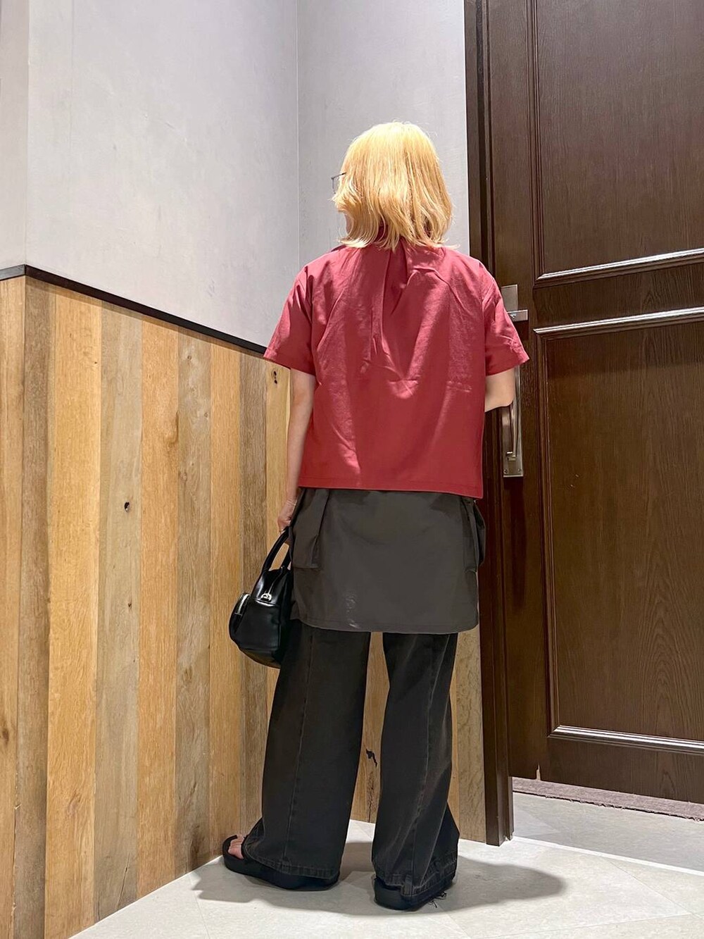 グレー系のスカート、ブラック系のデニムパンツ、レッド系のシャツ/ブラウスを着用したレディースの夏コーディネートの5枚目の写真