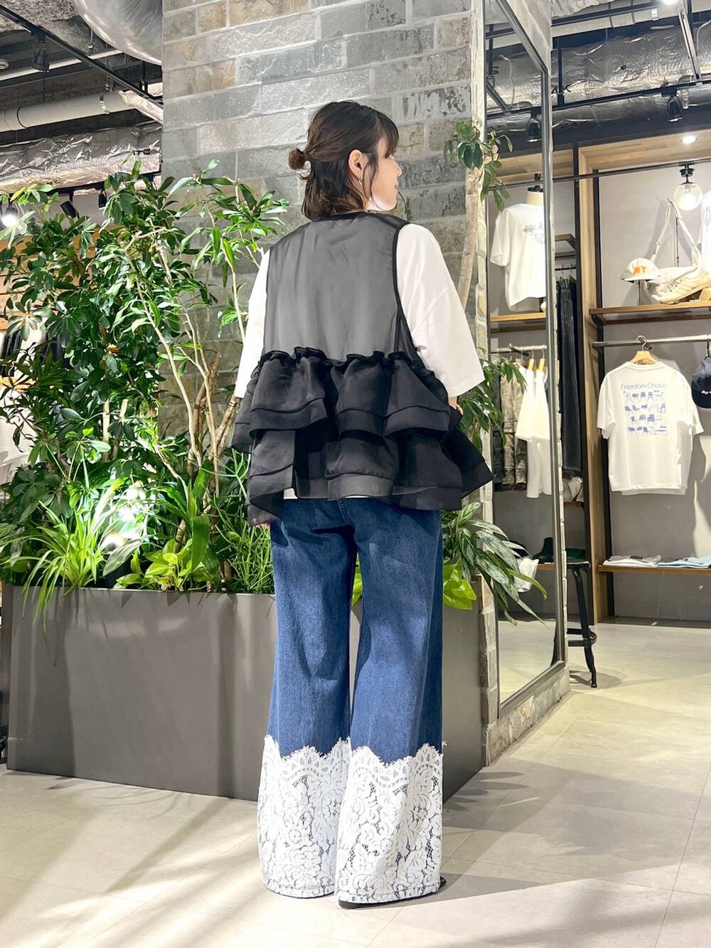 ホワイト系のTシャツ/カットソー、ブルー系のデニムパンツ、ブラック系のベストを着用したレディースの夏コーディネートの4枚目の写真