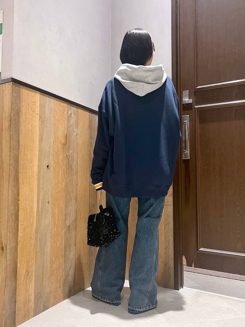 ブルー系のスウェット、ブルー系のデニムパンツ、グレー系のパーカーを着用したレディースの秋コーディネートの3枚目の写真