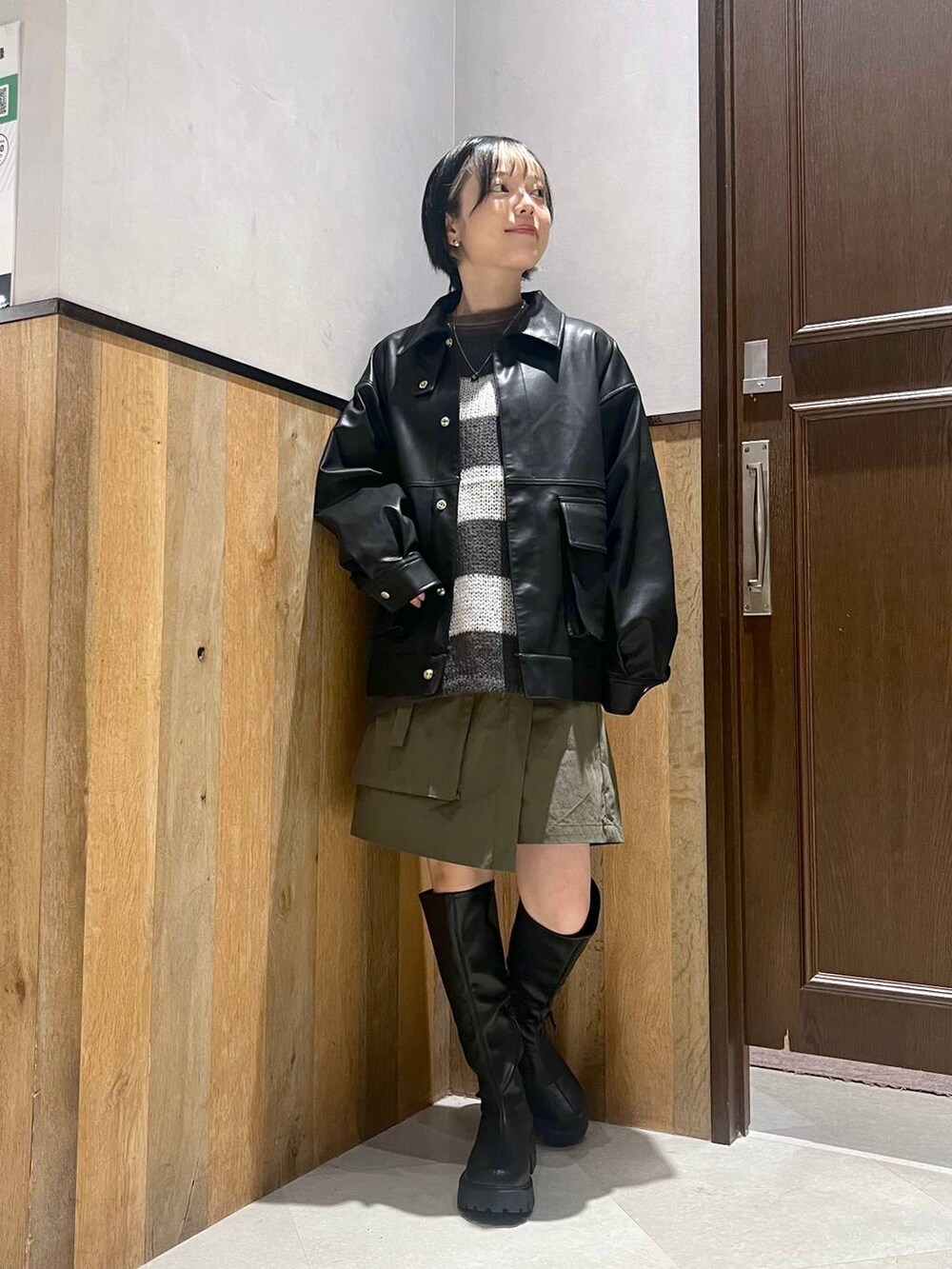 ブラック系のブーツ、ホワイト系のニット/セーター、ブラック系のブルゾンを着用したレディースの秋コーディネートの4枚目の写真