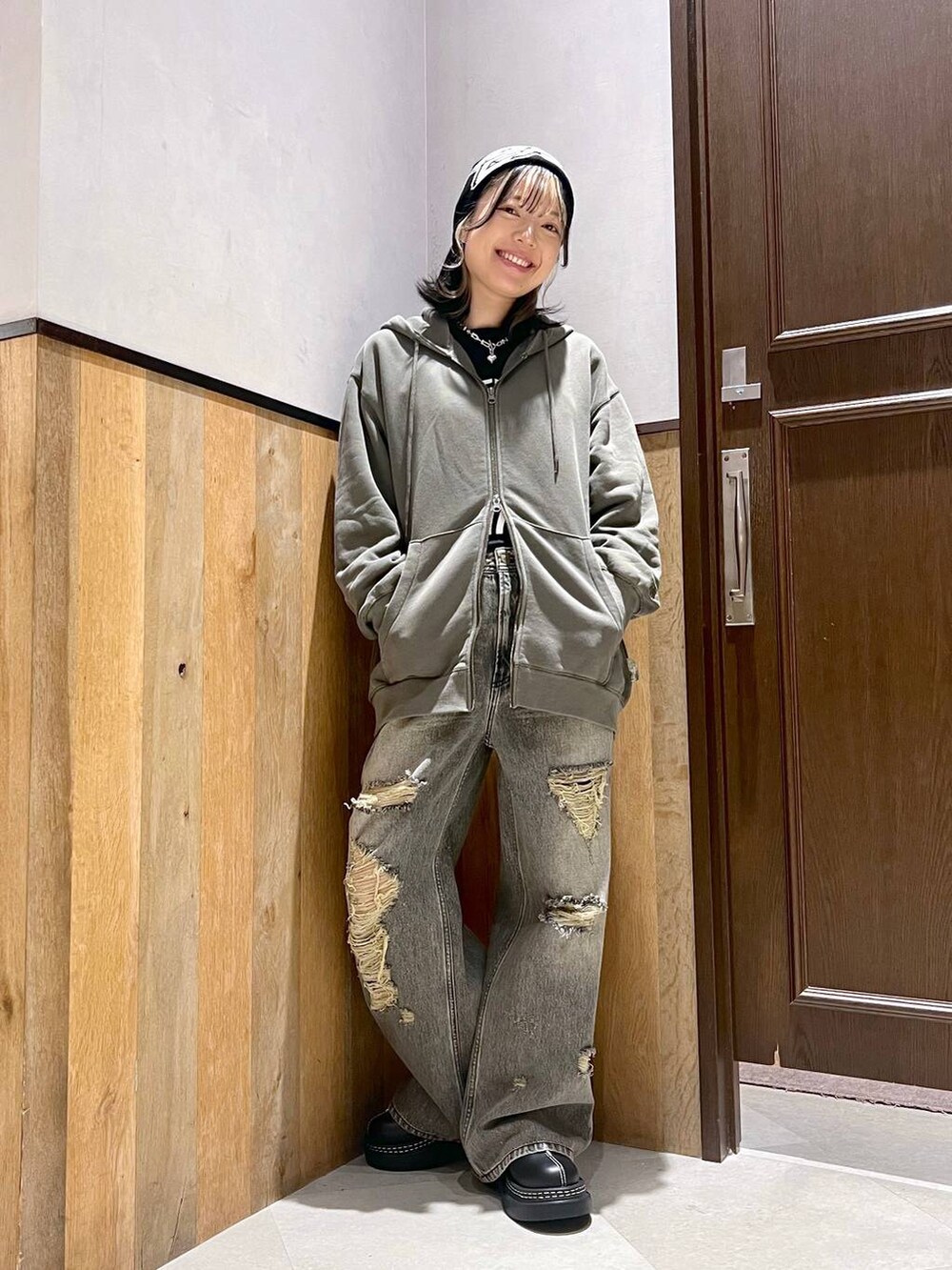 ブラック系のデニムパンツ、ブラック系のTシャツ/カットソー、グリーン系のパーカーを着用したレディースの秋コーディネートの4枚目の写真