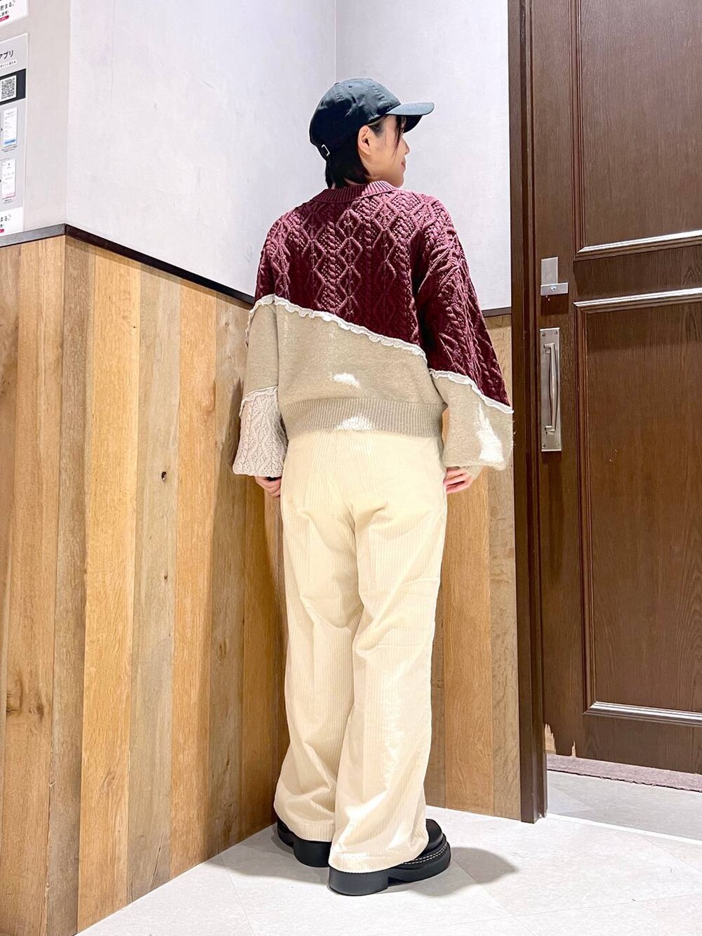 ホワイト系のスラックス、ブラック系のブルゾン、ブラック系のローファーを着用したレディースの秋コーディネートの6枚目の写真