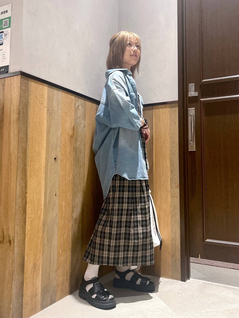 ブラック系のショルダーバッグ、ブラック系のワンピース、ホワイト系のキャミソールを着用したレディースの夏コーディネートの3枚目の写真