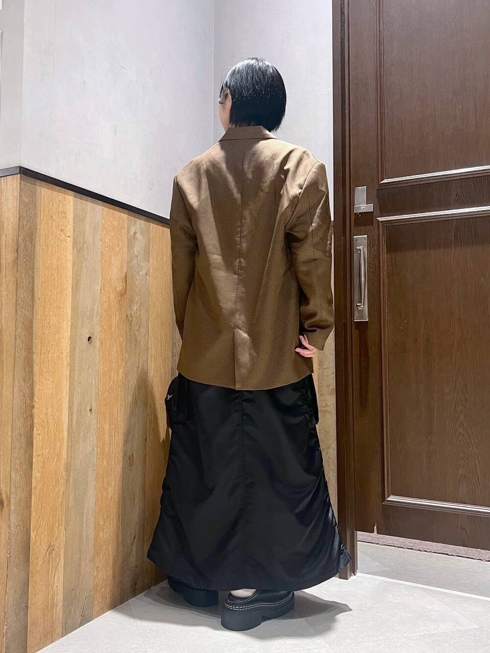 ブラック系のショルダーバッグ、ブラック系のスカート、ブラック系のローファーを着用したレディースの秋コーディネートの3枚目の写真