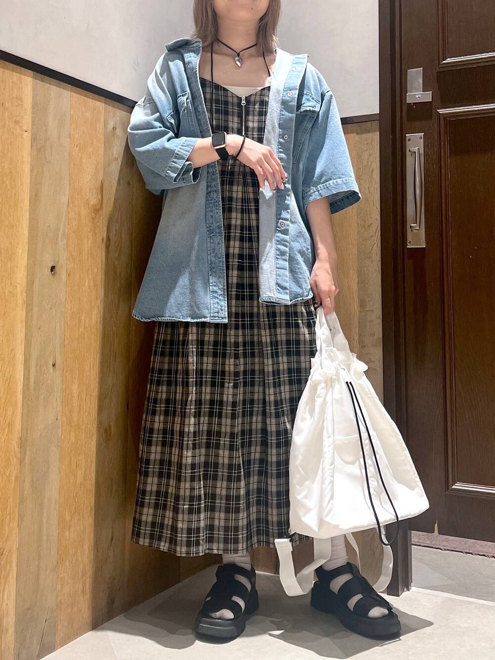 ブラック系のショルダーバッグ、ブラック系のワンピース、ホワイト系のキャミソールを着用したレディースの夏コーディネートの2枚目の写真