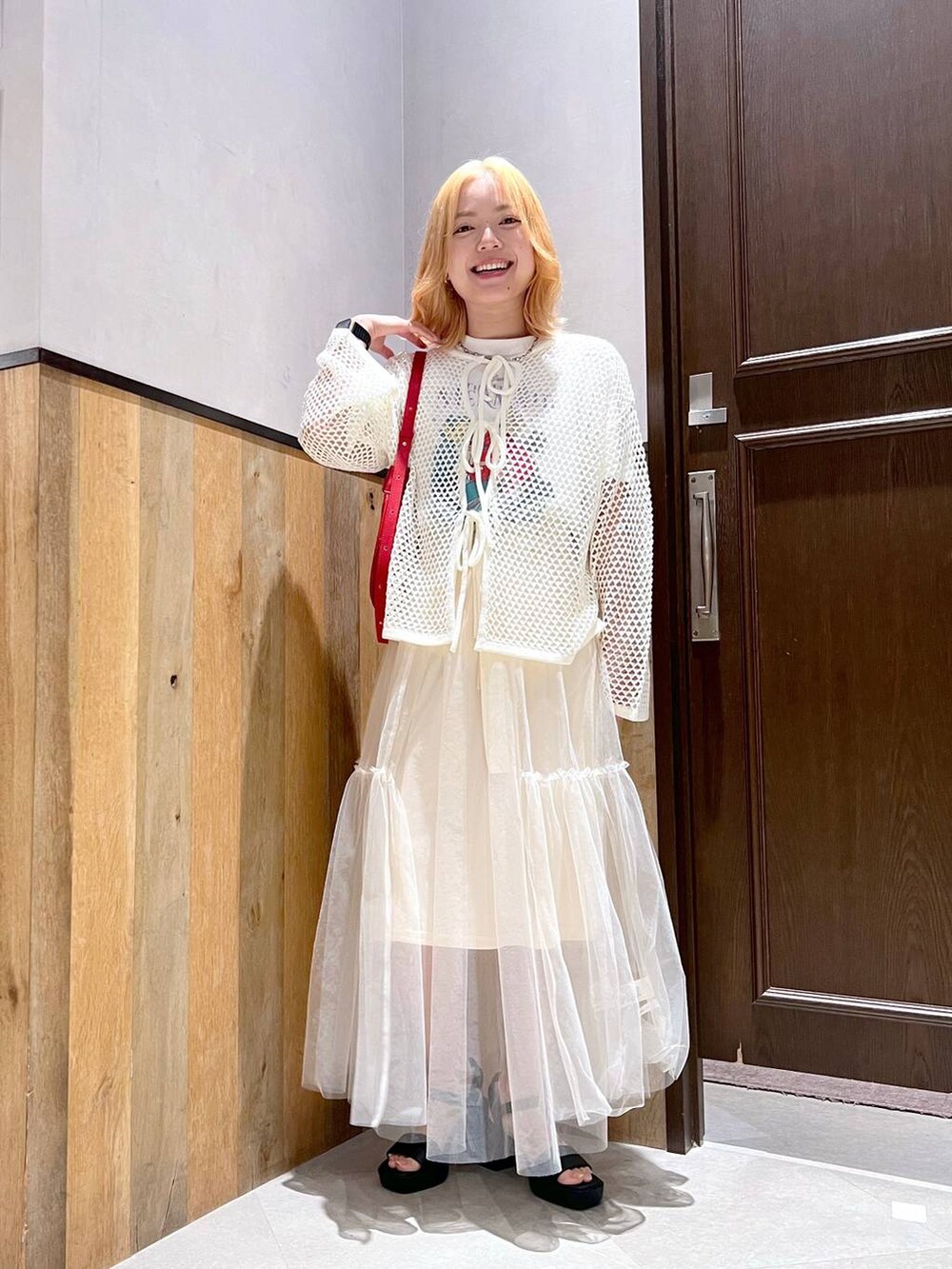 ブラック系のサンダル、ホワイト系のスカート、ホワイト系のカーディガン/ボレロを着用したレディースの夏コーディネートの4枚目の写真