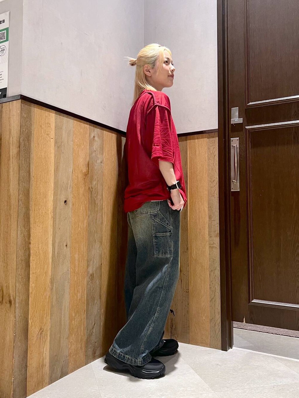 ブラック系のスニーカー、レッド系のTシャツ/カットソー、ブルー系のデニムパンツを着用したレディースの夏コーディネートの2枚目の写真