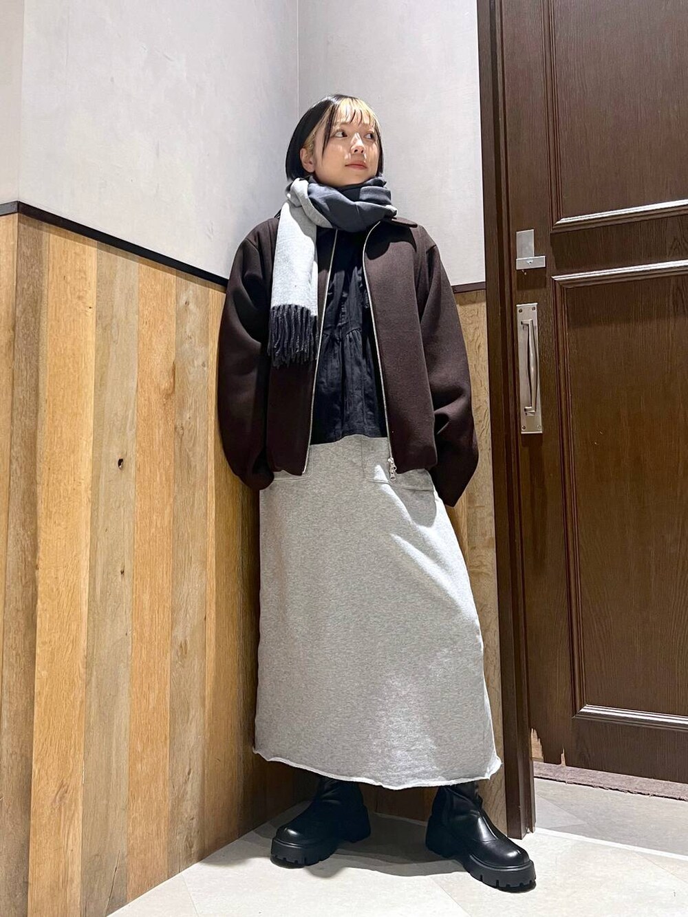 ブラウン系のブルゾン、ブラック系のブーツ、ブラック系のシャツ/ブラウスを着用したレディースの秋コーディネートの5枚目の写真