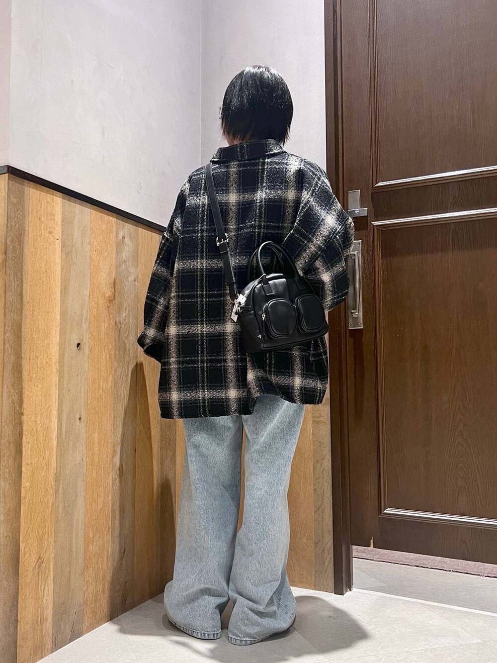 ブラック系のデニムパンツ、ブラック系のショルダーバッグ、ブラック系のシャツ/ブラウスを着用したレディースの秋コーディネートの3枚目の写真