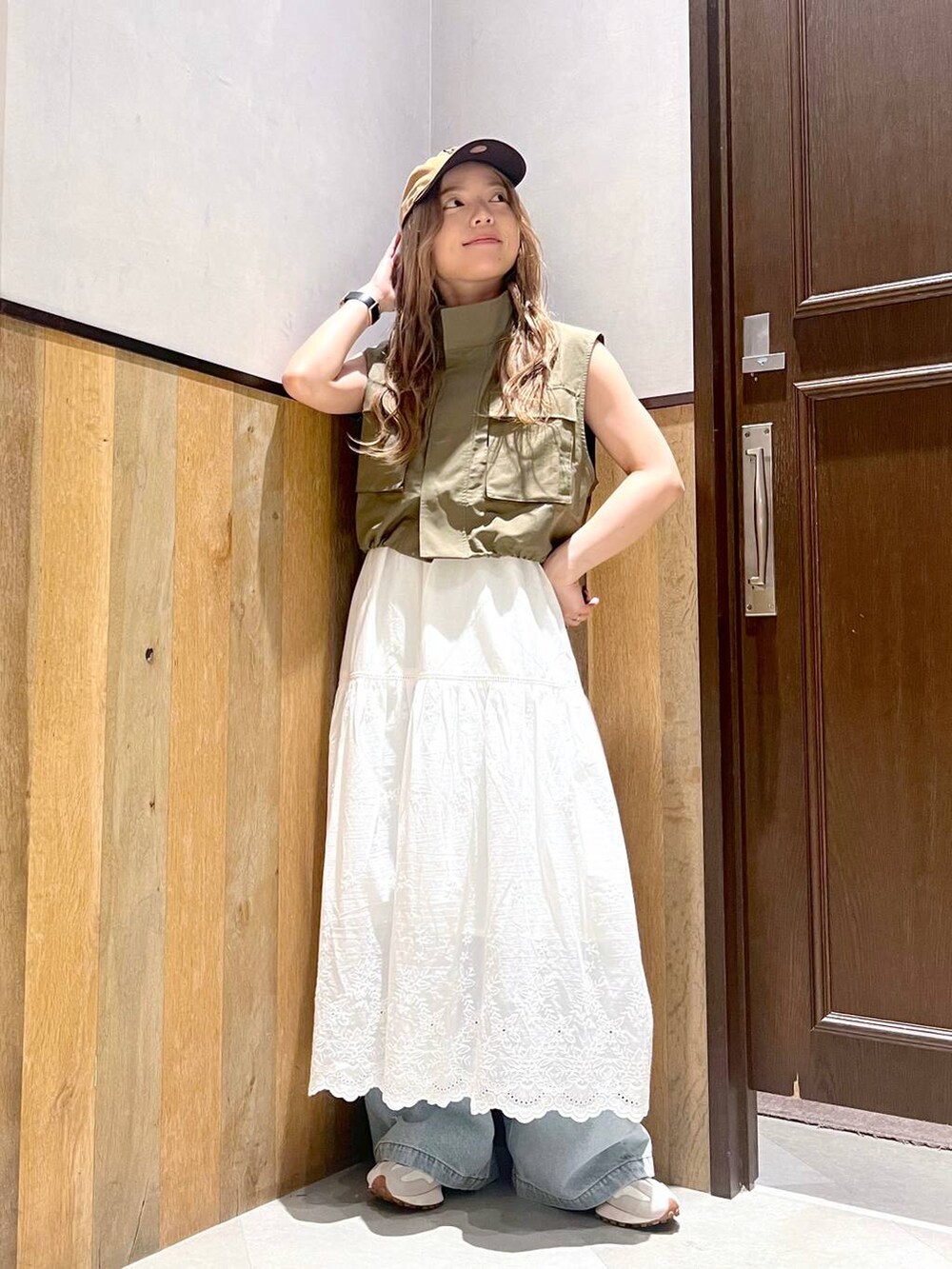 ブルー系のデニムパンツ、ブラック系のキャミソール、ホワイト系のスカートを着用したレディースの夏コーディネートの4枚目の写真