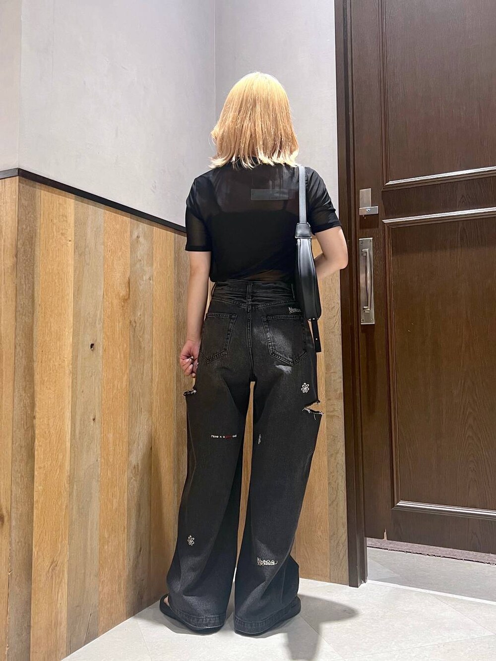 ブラック系のサンダル、ブルー系のデニムパンツ、ブラック系のTシャツ/カットソーを着用したレディースの夏コーディネートの4枚目の写真