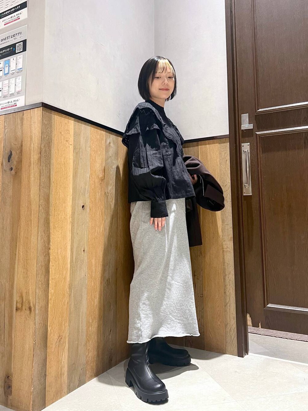 ブラウン系のブルゾン、ブラック系のブーツ、ブラック系のシャツ/ブラウスを着用したレディースの秋コーディネートの2枚目の写真