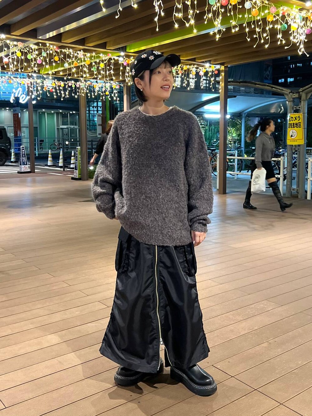 ブラック系のスカート、ブラック系のローファー、ブラウン系のニット/セーターを着用したレディースの秋コーディネートの2枚目の写真