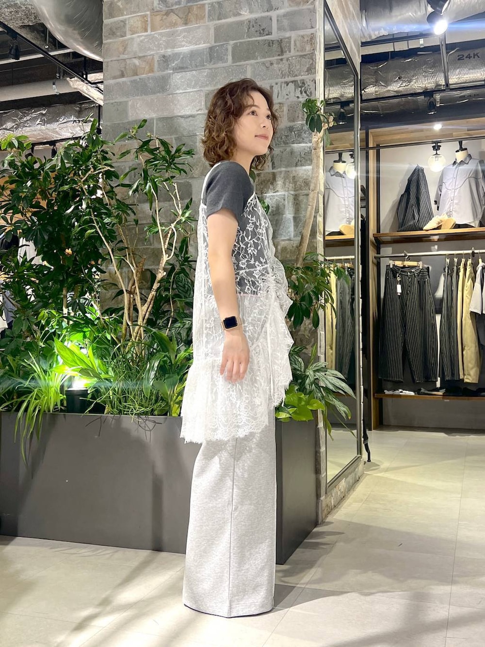 ホワイト系のワンピース、ブラック系のサンダル、グレー系のスウェットパンツを着用したレディースの夏コーディネートの3枚目の写真