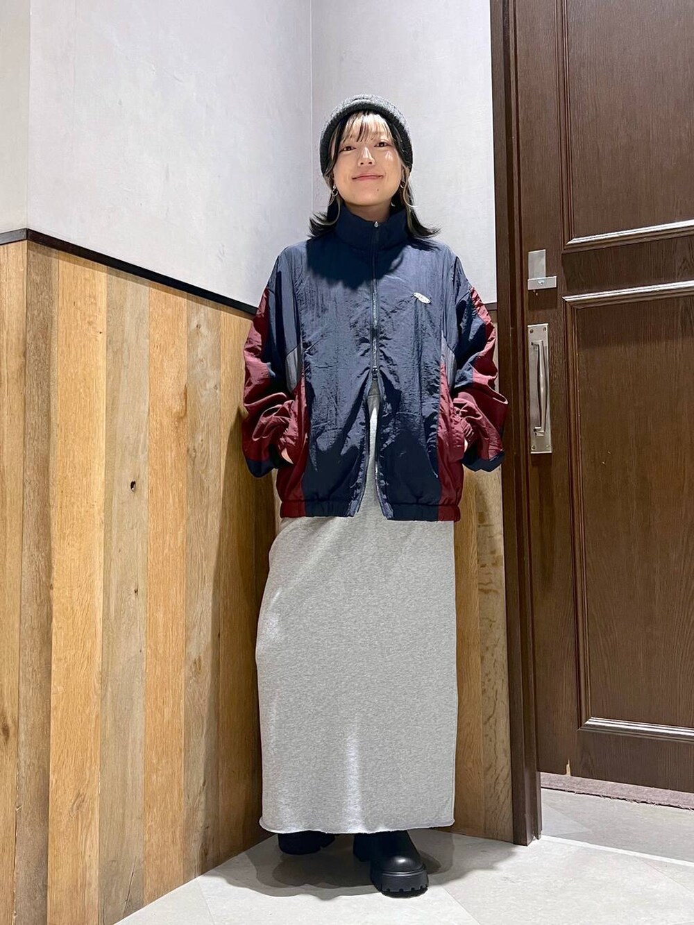 ホワイト系のTシャツ/カットソー、ブルー系のブルゾン、ブラック系のブーツを着用したレディースの秋コーディネートの2枚目の写真