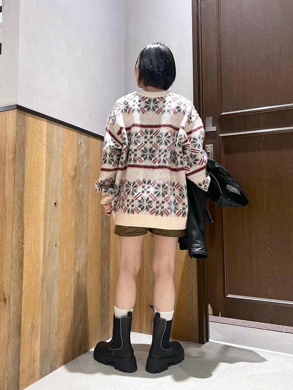 ブラック系のブーツ、ホワイト系のニット/セーター、ブラック系のブルゾンを着用したレディースの秋コーディネートの7枚目の写真