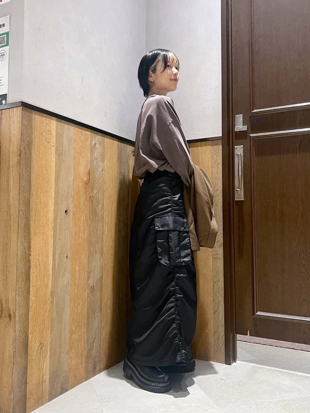 ブラック系のショルダーバッグ、ブラック系のスカート、ブラック系のローファーを着用したレディースの秋コーディネートの6枚目の写真