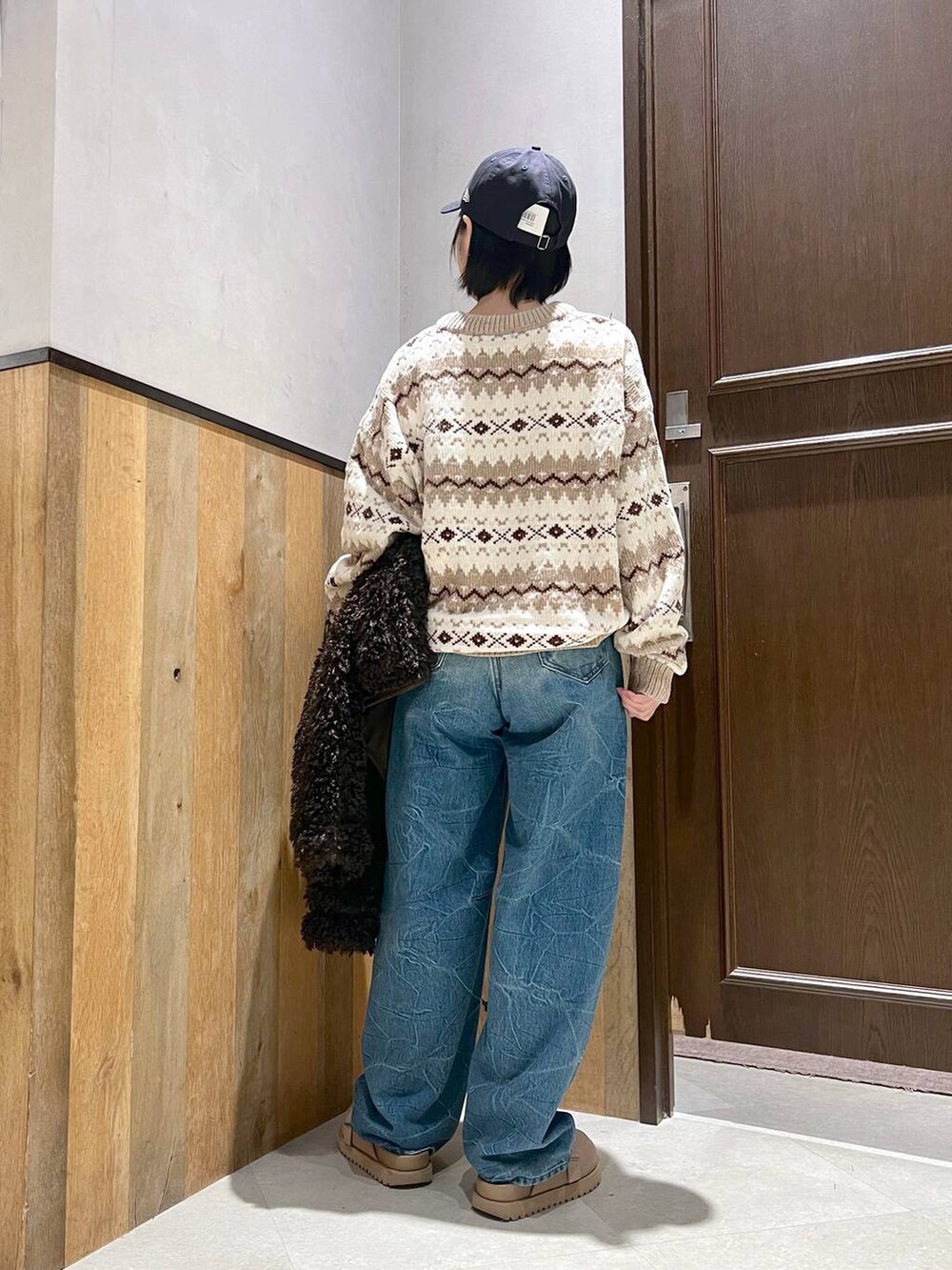 ホワイト系のニット/セーター、ブラウン系のブルゾン、ブルー系のデニムパンツを着用したレディースの秋コーディネートの4枚目の写真