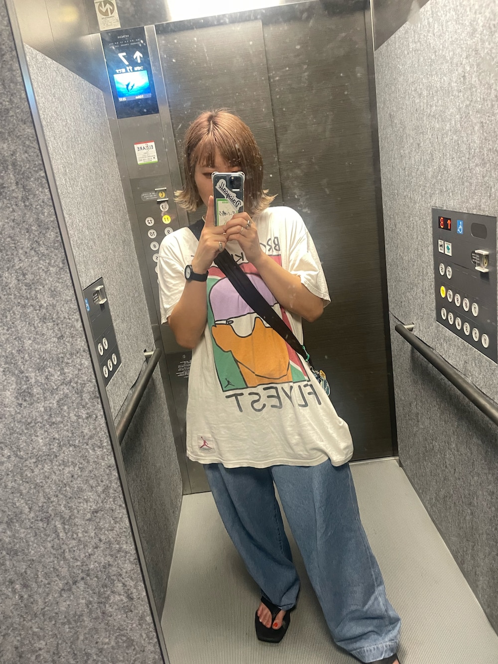 ホワイト系のTシャツ/カットソー、ブラック系のショルダーバッグ、ブルー系のデニムパンツを着用したレディースの夏コーディネートの2枚目の写真