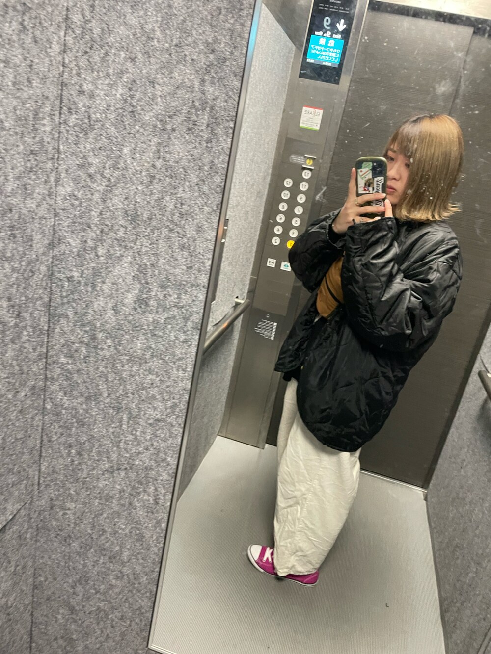 ホワイト系のパンツ、ピンク系のスニーカー、ブラック系のジャケット/アウターを着用したレディースの冬コーディネートの2枚目の写真