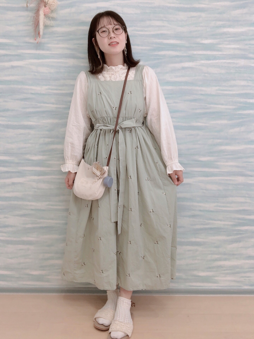 ホワイト系のシャツ/ブラウス、グリーン系のワンピース、ホワイト系のバッグを着用したレディースの春コーディネートの3枚目の写真