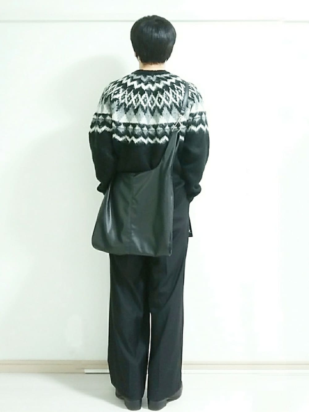 ブラック系のブーツ、ブラック系のスラックス、ブラック系のニット/セーターを着用したメンズの冬コーディネートの3枚目の写真