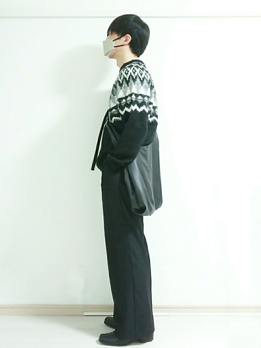 ブラック系のブーツ、ブラック系のスラックス、ブラック系のニット/セーターを着用したメンズの冬コーディネートの2枚目の写真