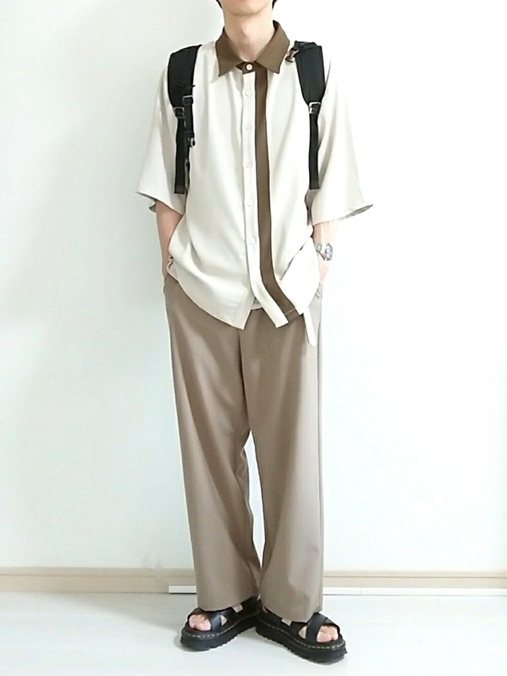 ブラック系のサンダル、ブラック系のバックパック/リュック、ベージュ系のその他パンツを着用したメンズの秋コーディネートの2枚目の写真