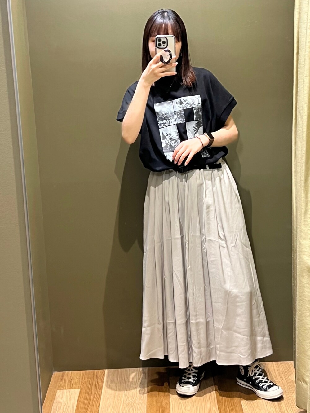 ブラック系のスニーカー、ベージュ系のスカート、ブラック系のTシャツ/カットソーを着用したレディースの夏コーディネートの2枚目の写真