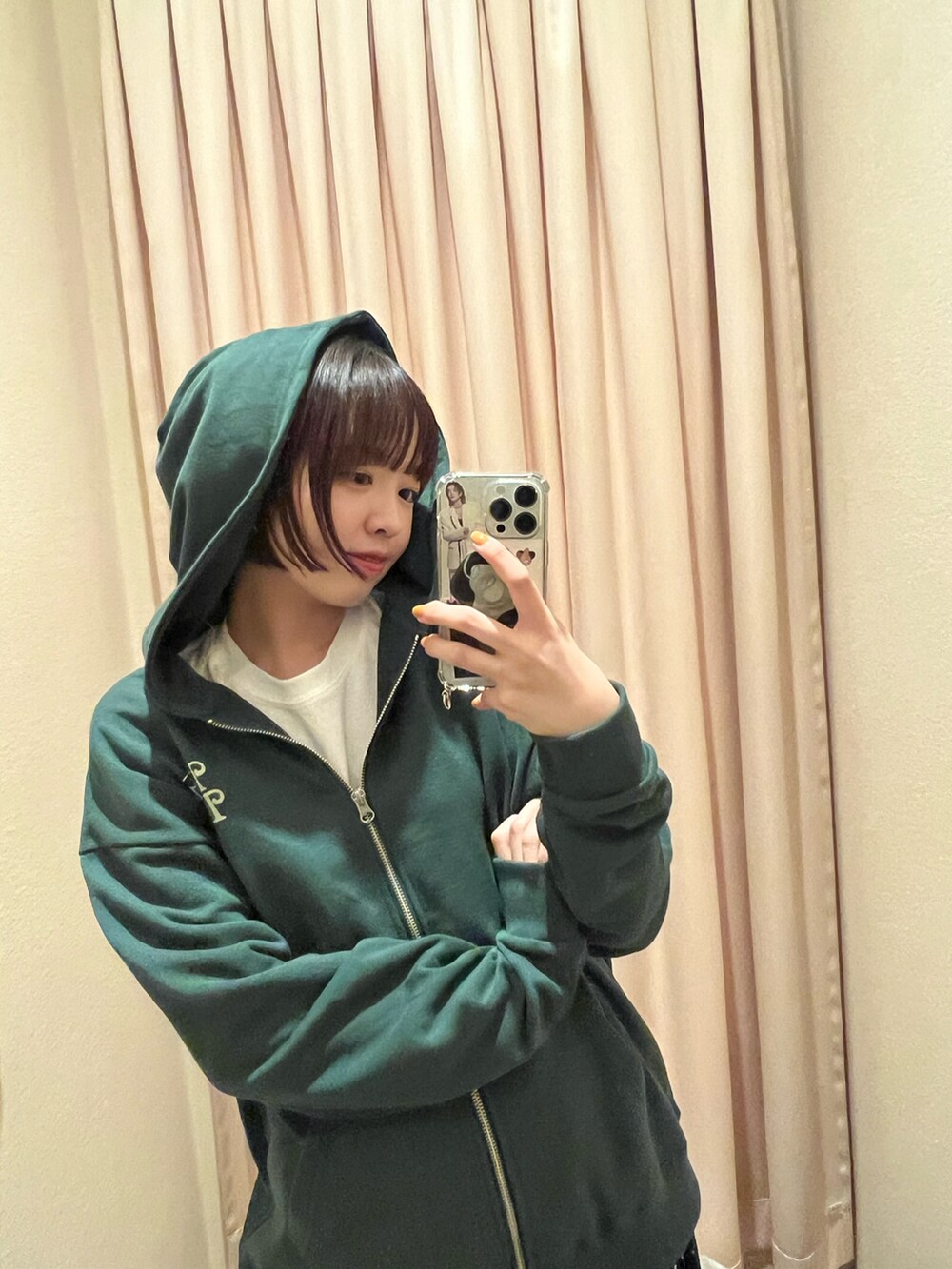 グリーン系のパーカー、ホワイト系のTシャツ/カットソー、ブラック系のスカートを着用したレディースの秋コーディネートの3枚目の写真