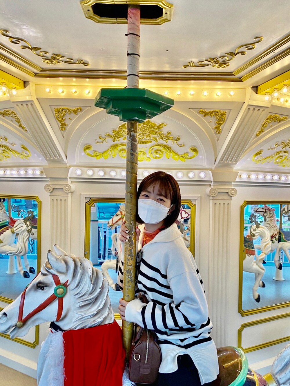 ホワイト系のニット/セーター、オレンジ系のTシャツ/カットソー、ブラック系のスラックスを着用したレディースの秋コーディネートの2枚目の写真