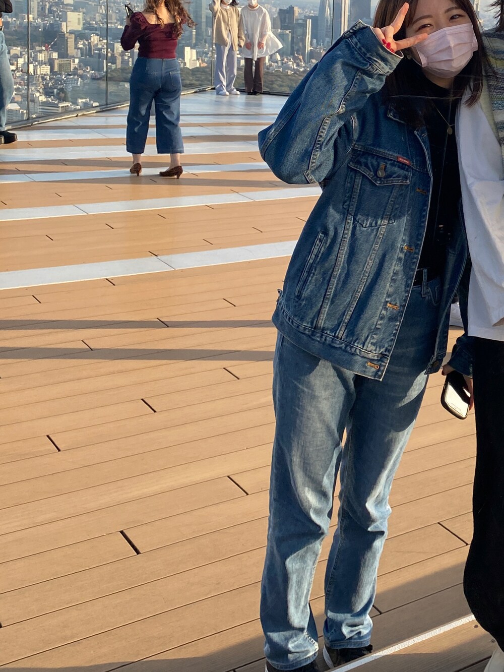 ブルー系のデニムパンツ、ブルー系のデニムジャケットを着用したレディースの夏コーディネートの2枚目の写真