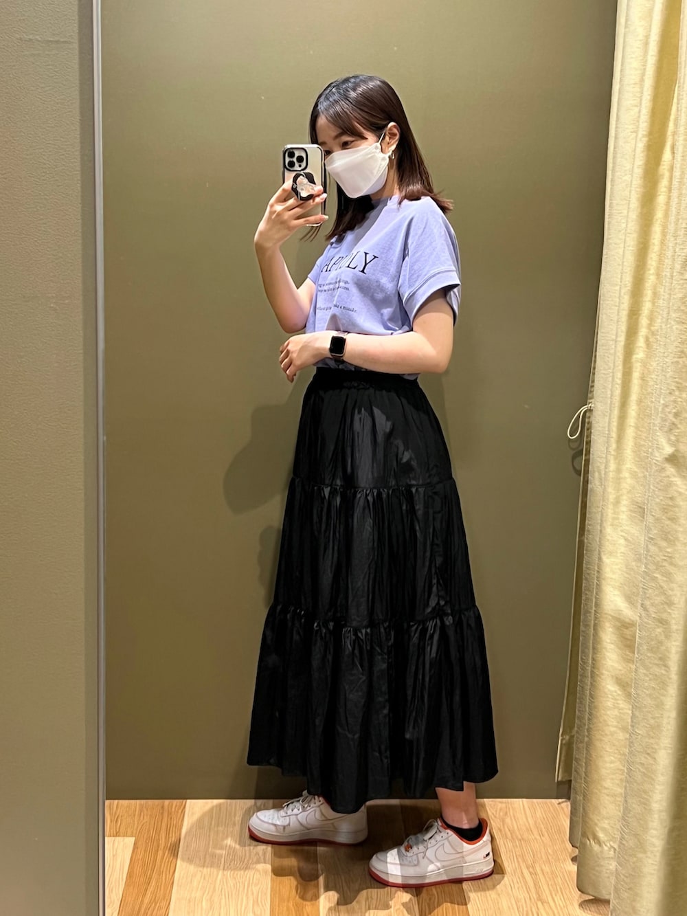 パープル系のチュニック、ブラック系のスカート、オレンジ系のスニーカーを着用したレディースの夏コーディネートの2枚目の写真