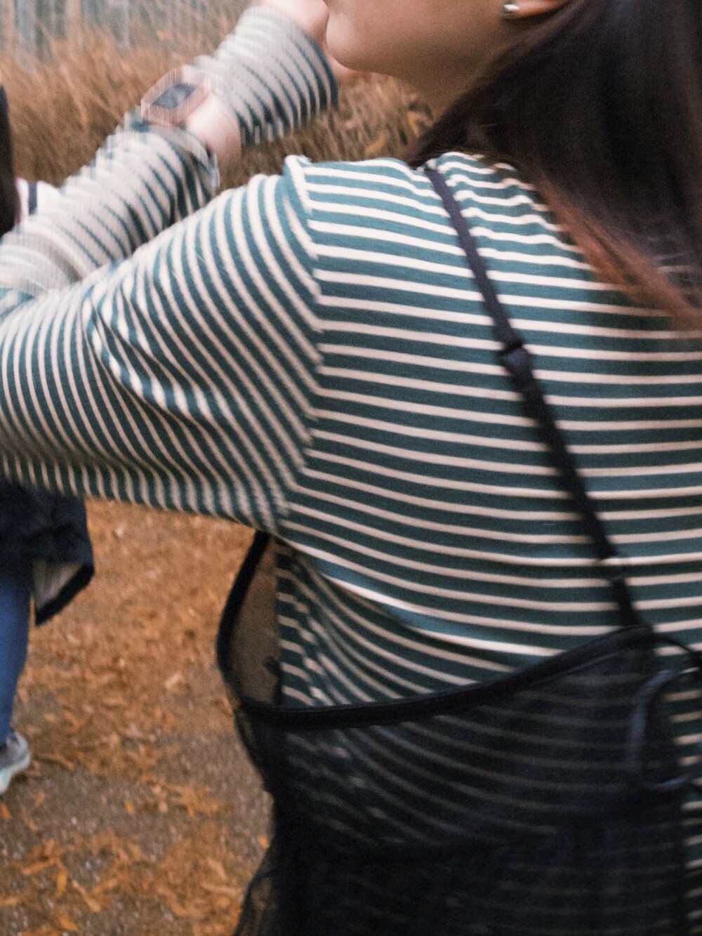 ブラック系のキャミソール、ホワイト系のパンツ、グリーン系のTシャツ/カットソーを着用したレディースの春コーディネートの2枚目の写真