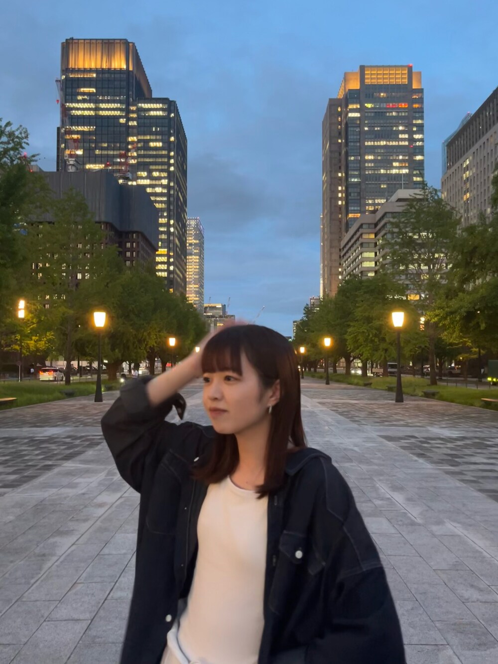 ホワイト系のキャミソール、ブルー系のチュニック、ホワイト系のデニムパンツを着用したレディースの夏コーディネートの3枚目の写真