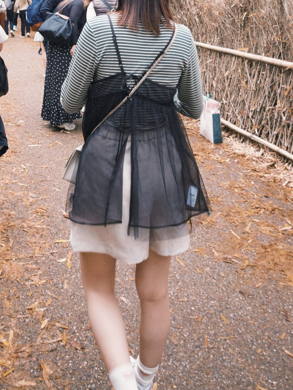 ブラック系のキャミソール、ホワイト系のパンツ、グリーン系のTシャツ/カットソーを着用したレディースの春コーディネートの3枚目の写真