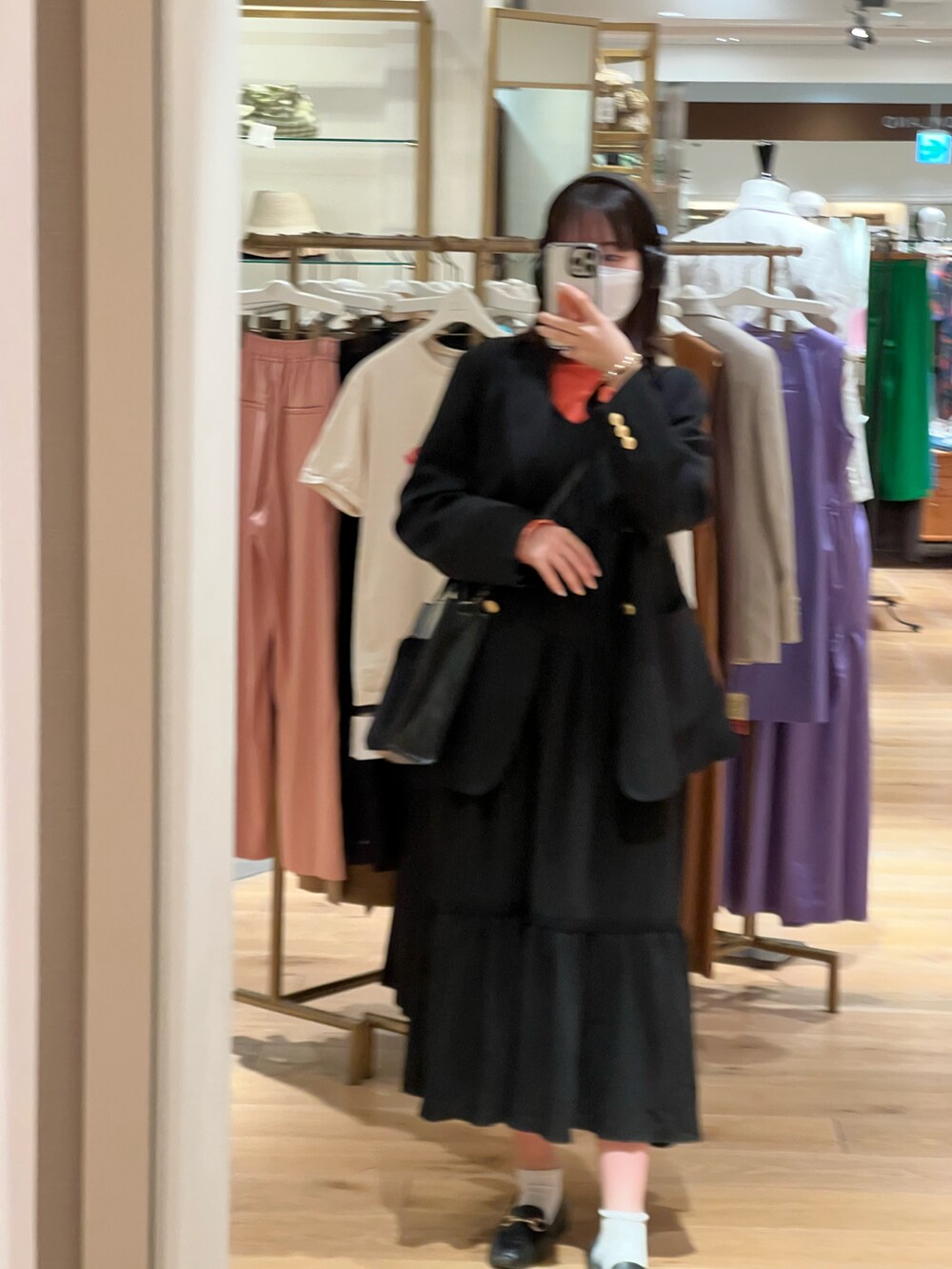 ブラック系のショルダーバッグ、ブラック系のワンピース、ブルー系のテーラードジャケットを着用したレディースの春コーディネートの2枚目の写真