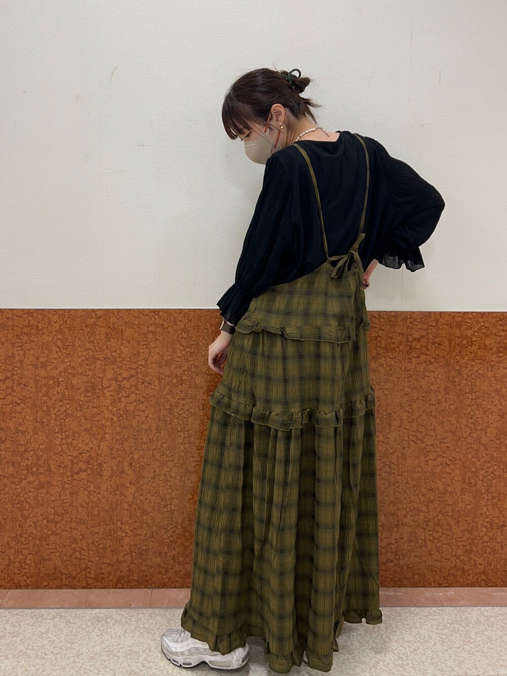 グリーン系のワンピース、ブラック系のTシャツ/カットソー、ホワイト系のスニーカーを着用したレディースの夏コーディネートの3枚目の写真