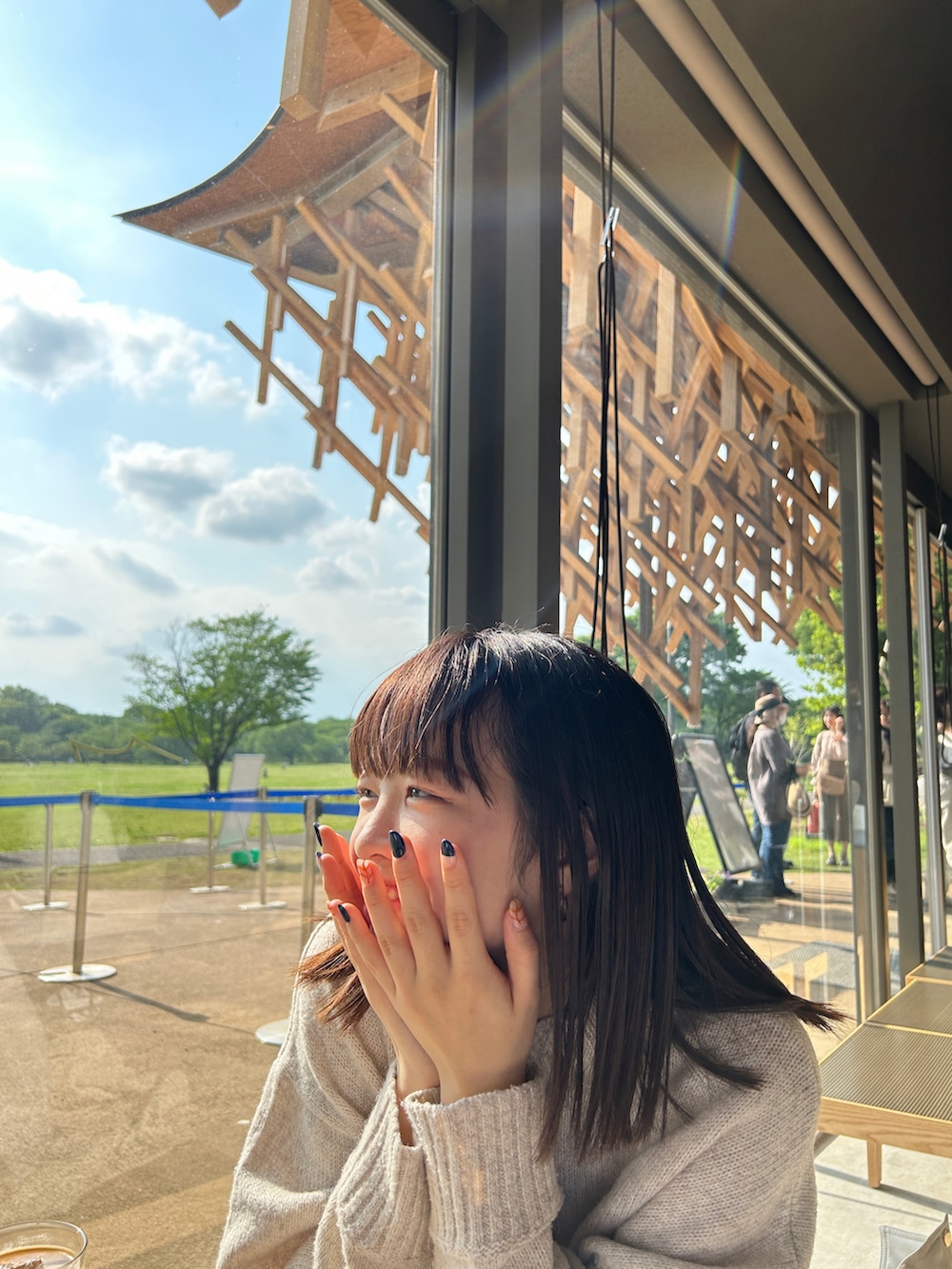 ベージュ系のニット/セーター、グレー系のスラックス、ブラック系のスニーカーを着用したレディースの春コーディネートの4枚目の写真