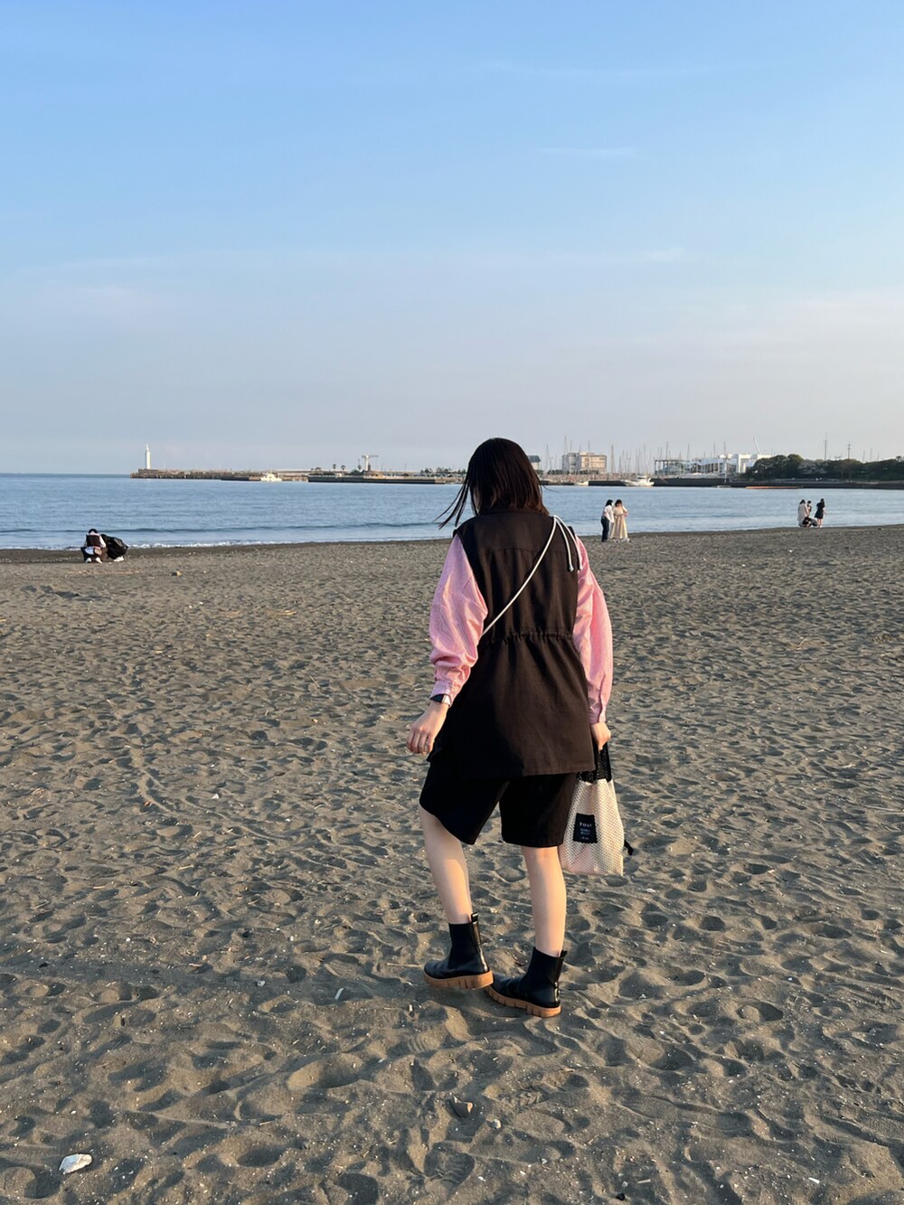 ブラック系のブーツ、ブラック系のその他パンツ、ブラック系のベストを着用したレディースの春コーディネートの2枚目の写真