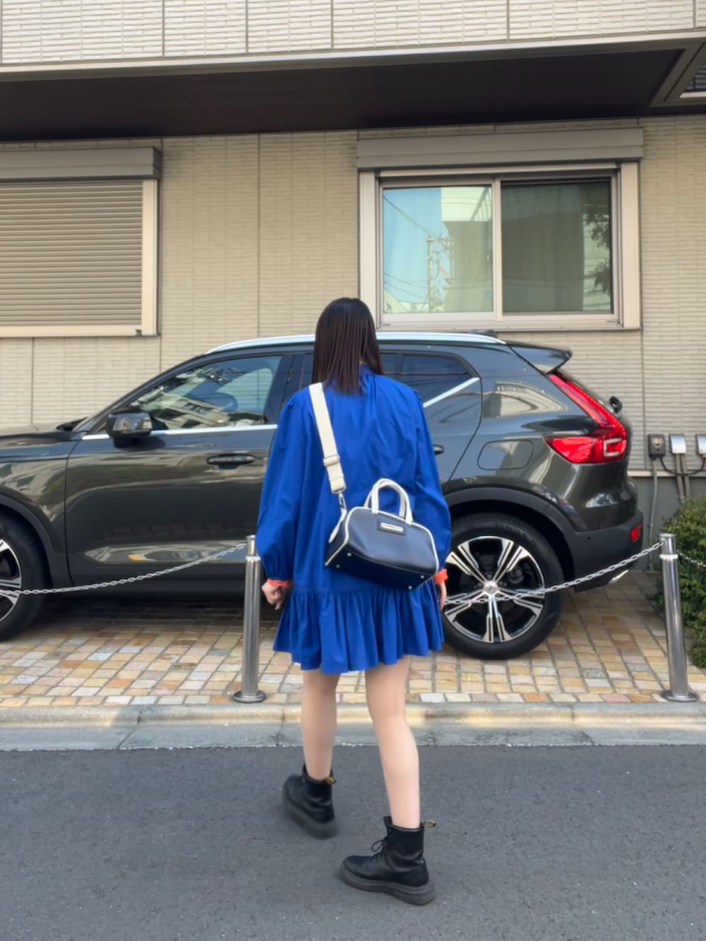 ブラック系のブーツ、ブルー系のボストンバッグ、ブルー系のトップスを着用したレディースの春コーディネートの2枚目の写真