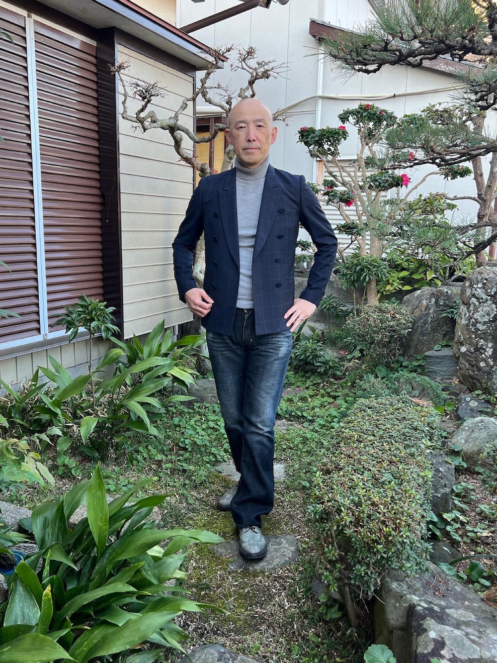 ブラック系のテーラードジャケット、ブラック系のデニムパンツ、グレー系のドレスシューズを着用したメンズの冬コーディネートの3枚目の写真