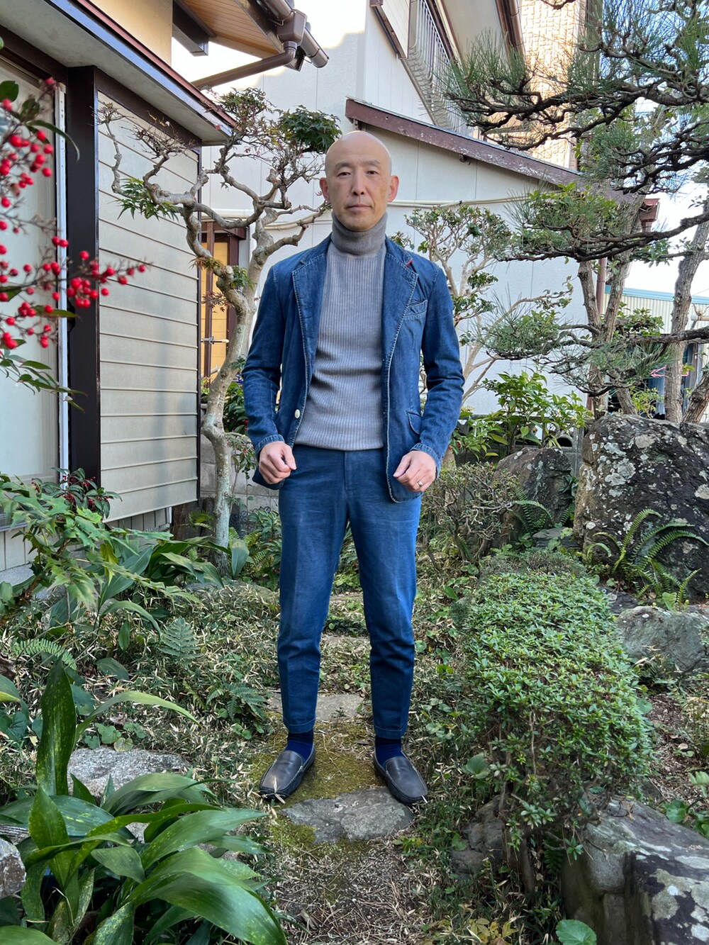 ブルー系のデニムジャケット、グレー系のニット/セーター、ブルー系のデニムパンツを着用したメンズの冬コーディネートの2枚目の写真