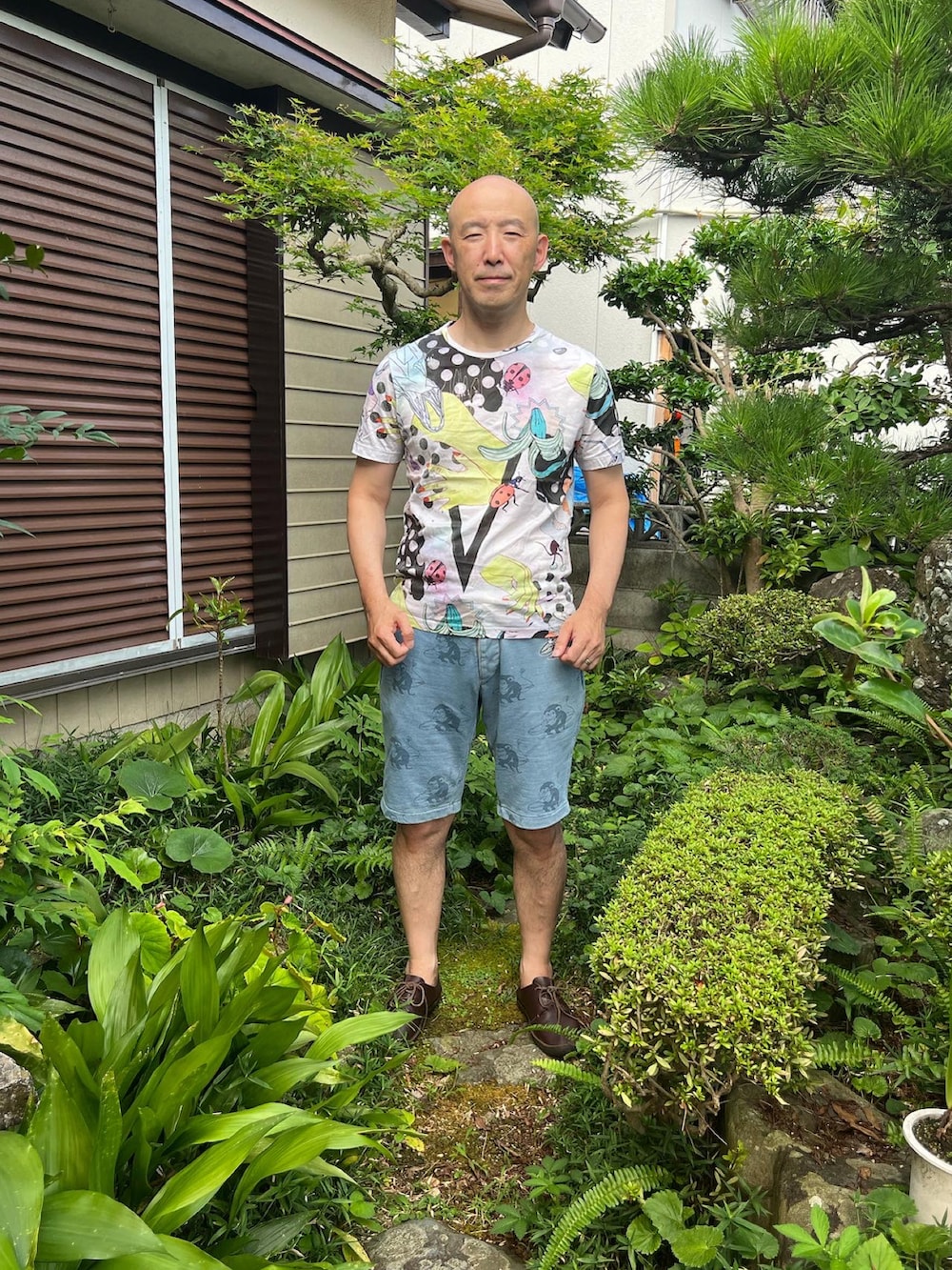 ホワイト系のTシャツ/カットソー、グレー系のパンツ、ブラウン系のスニーカーを着用したメンズの夏コーディネートの2枚目の写真