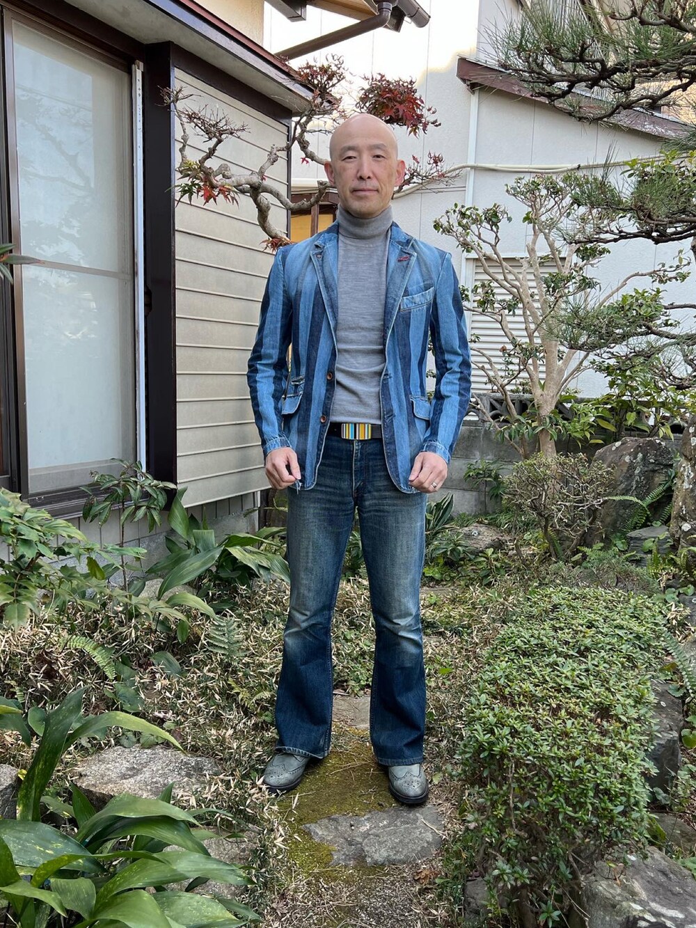 ブルー系のデニムジャケット、グレー系のニット/セーター、ブルー系のデニムパンツを着用したメンズの冬コーディネートの2枚目の写真