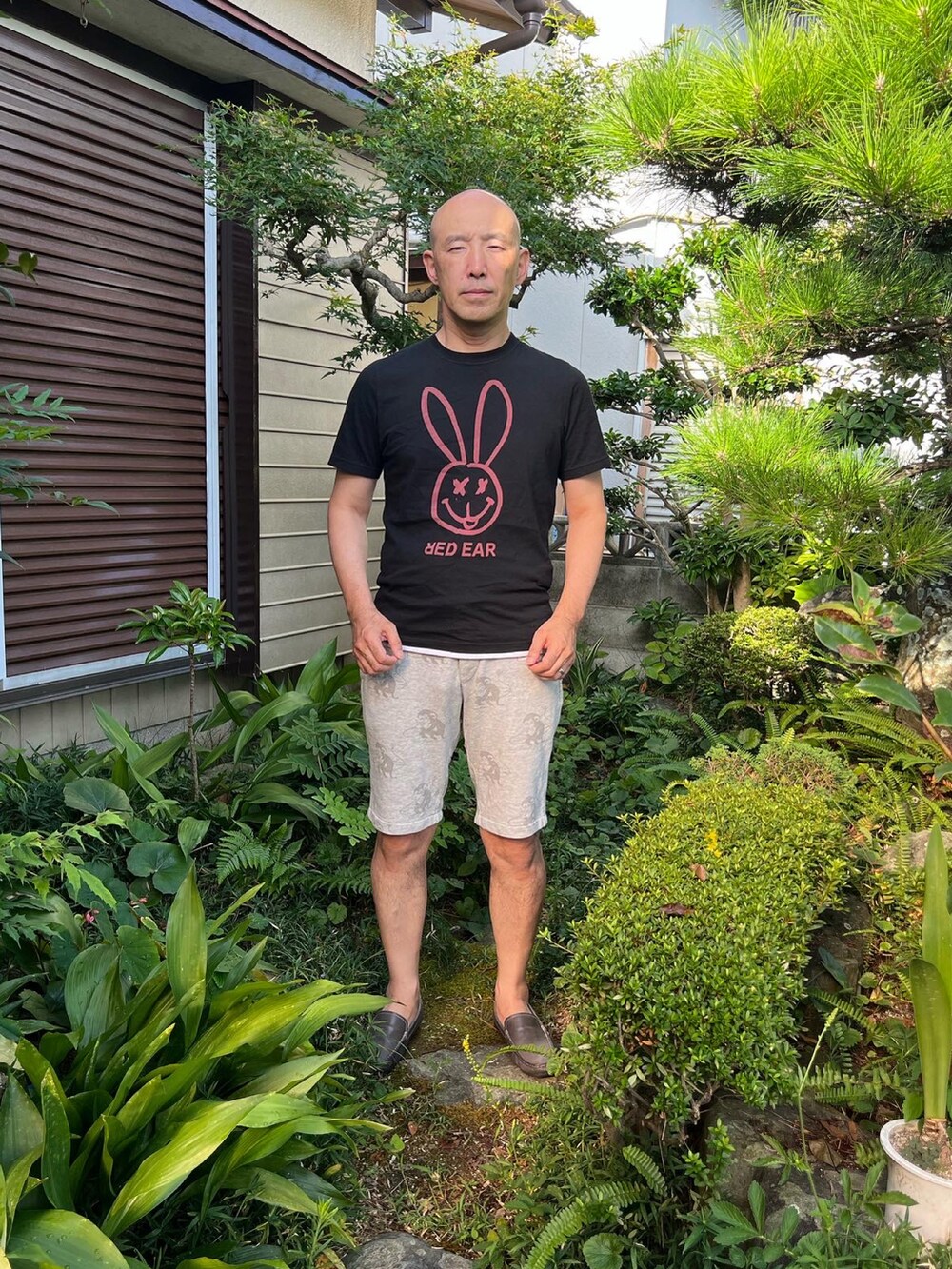 ブラック系のTシャツ/カットソー、シルバー系のパンツ、ブルー系のローファーを着用したメンズの夏コーディネートの2枚目の写真