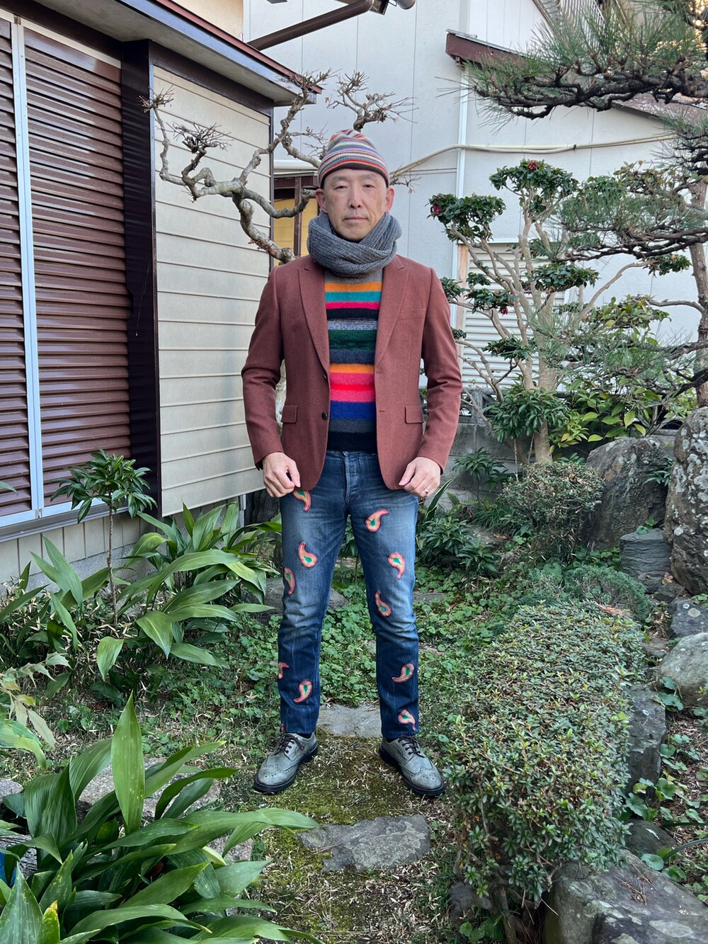 ブラウン系のテーラードジャケット、ブルー系のデニムパンツ、グレー系のドレスシューズを着用したメンズの冬コーディネートの2枚目の写真