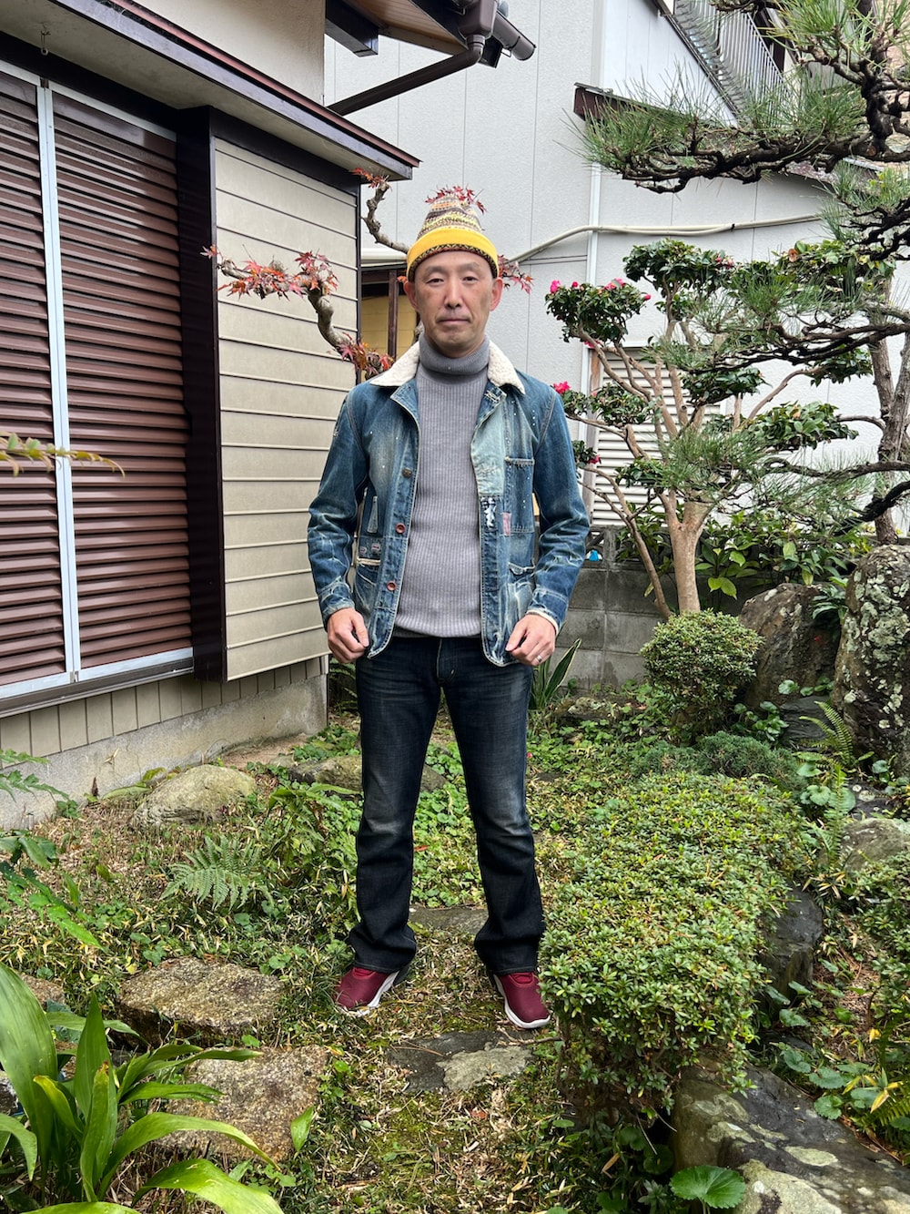 ブルー系のデニムジャケット、グレー系のニット/セーター、ブラック系のデニムパンツを着用したメンズの冬コーディネートの2枚目の写真